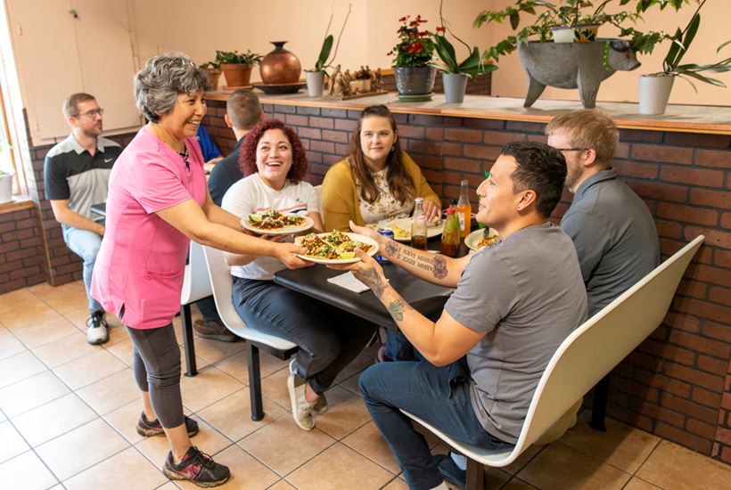 Woman serves food to people