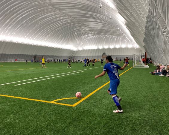 Man with soccer ball on indoor turf grass